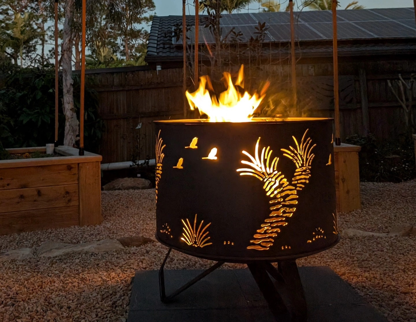 H&S Metalcraft: a laser cut firepit in a backyard at dusk